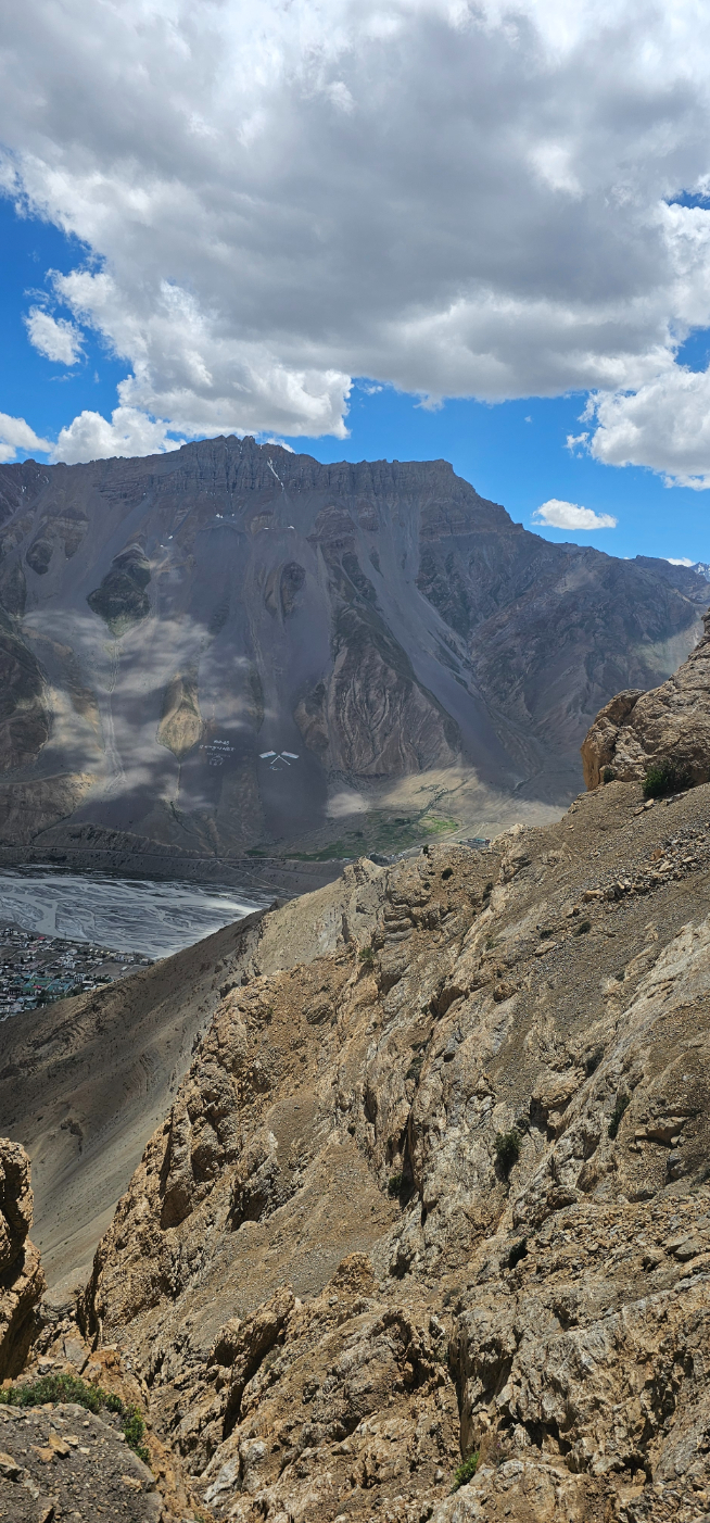 A close-up view of a rugged, snowy mountain peak against a blue sky