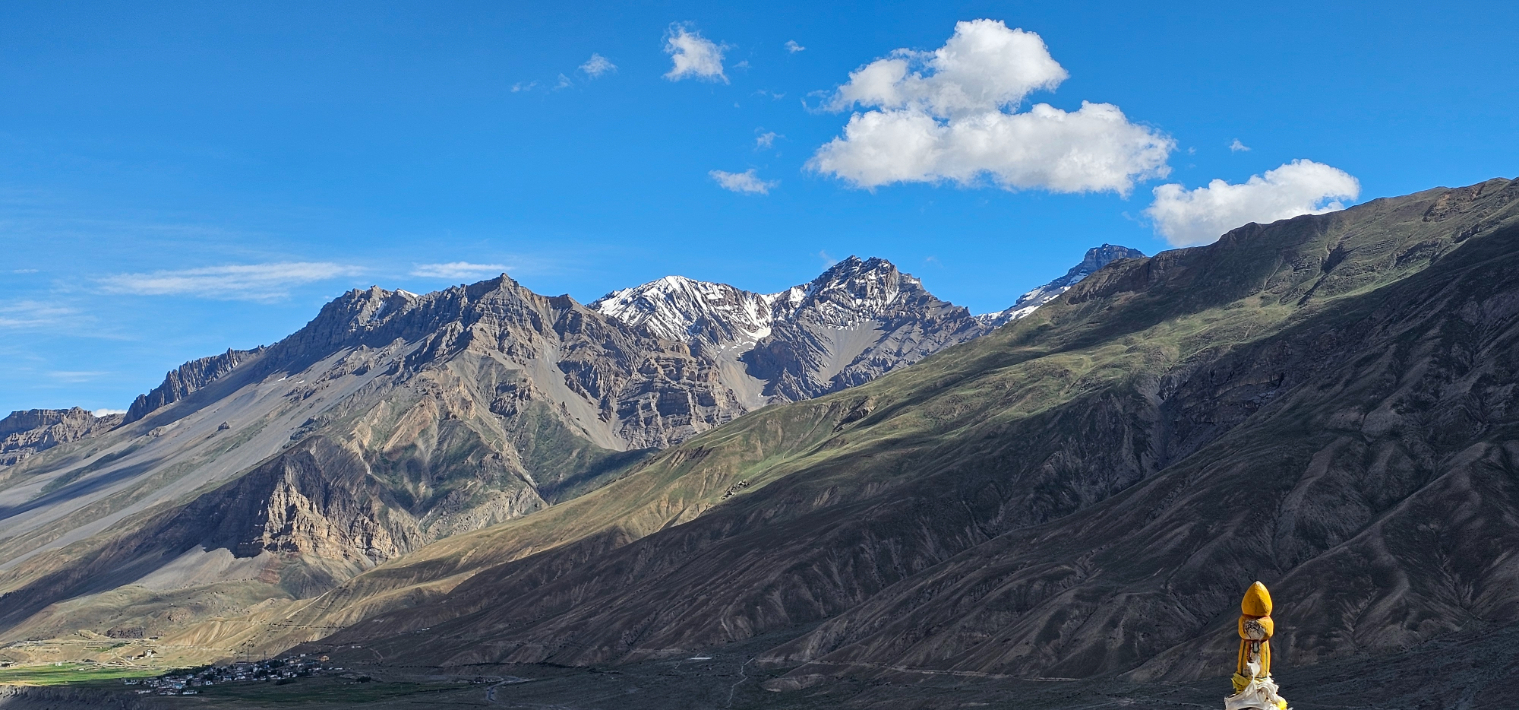 View from a monastery overlooking a wide valley with a river and green fields